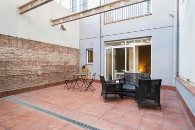 a patio with chairs and a table in a building at Stay U-nique Apartments Vila de Gracia II in Barcelona