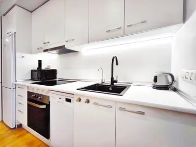 a white kitchen with white cabinets and a sink at Moderno apartamento tipo loft en Terrassa centro in Terrassa