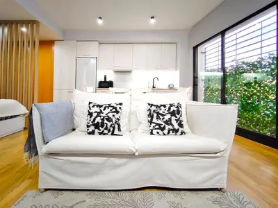 a living room with a white couch with pillows at Moderno apartamento tipo loft en Terrassa centro in Terrassa