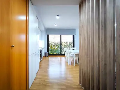 a kitchen and dining room with a table and a hallway at Moderno apartamento tipo loft en Terrassa centro in Terrassa