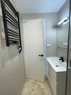a bathroom with a white door and a sink at Barri Vell 4 in Manresa