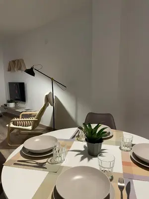 a dining room table with plates and a lamp at Barri Vell 4 in Manresa