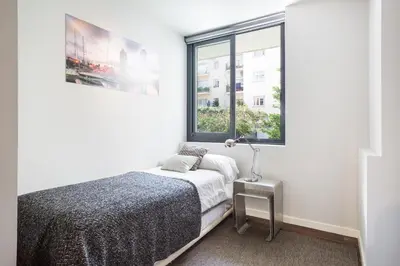 a white bedroom with a bed and a window at My Space Emirates - Modern Duplex with Private Garden and Swimming Pool in Barcelona