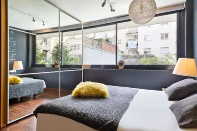 a bedroom with a bed and a large window at My Space Emirates - Modern Duplex with Private Garden and Swimming Pool in Barcelona