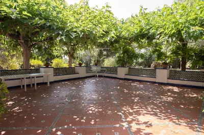 a patio with benches and trees in a park at SITGES Masia Sències in Sitges