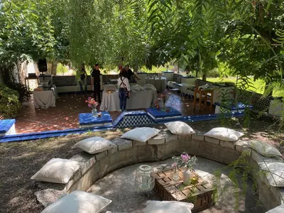 a patio with pillows and tables under a tree at SITGES Masia Sències in Sitges