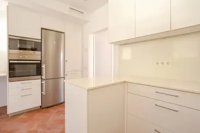 a kitchen with white cabinets and a stainless steel refrigerator at SITGES Masia Sències in Sitges