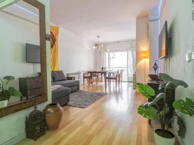 a living room with a couch and a dining room at Araia Apartment by Hello Homes Sitges in Sitges