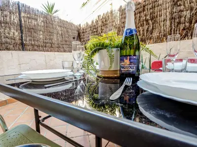 a glass table with a bottle of wine on it at Araia Apartment by Hello Homes Sitges in Sitges