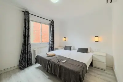 a bedroom with two beds and a window at Bed&BCN Mas Apartments in Hospitalet de Llobregat