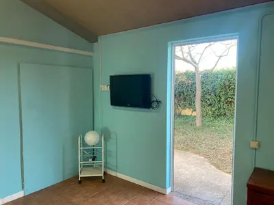 a room with a sliding glass door with a television on the wall at La Geneta Casa Vacacional in Vilobi Del Penedes