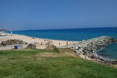 a beach with a bunch of people on the beach at Apartamento al lado de Barcelona y la playa in Montgat