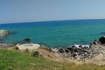 a large body of water with rocks and the ocean at Apartamento al lado de Barcelona y la playa in Montgat