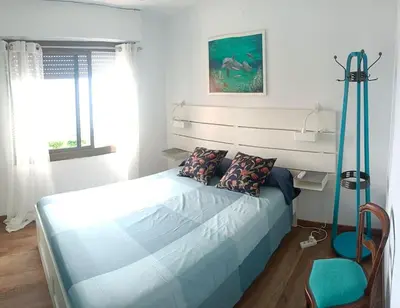 a bedroom with a bed with a blue bed frame at Apartamento al lado de Barcelona y la playa in Montgat