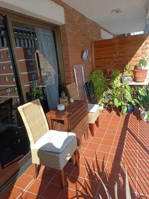 a patio with chairs and a wooden table and a table at Apartamento al lado de Barcelona y la playa in Montgat