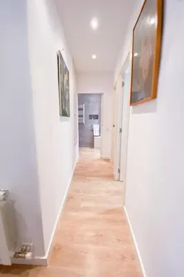 a hallway with white walls and a wooden floor at Anna & Thomas - Sitges Center Apt in Sitges