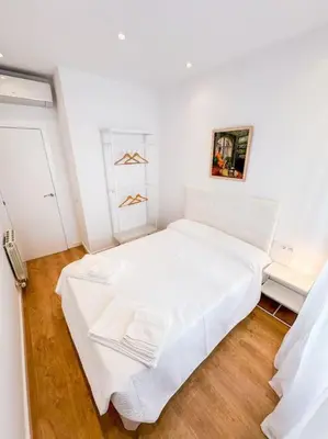 a bedroom with a white bed in a room at Anna & Thomas - Sitges Center Apt in Sitges