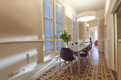 a dining room with a table and chairs and windows at My Space Emirates - Apartments in Rambla de Catalunya in Barcelona