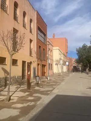 an empty city street with buildings and a tree at Loft estilo industrial en Esplugues - 15 min de Barcelona in Esplugues de Llobregat