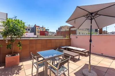 a patio with a table and chairs and an umbrella at My Space Emirates - Bright Apartment in Gracia with shared Pool in Barcelona
