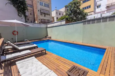 a swimming pool with two chairs and an umbrella at My Space Emirates - Bright Apartment in Gracia with shared Pool in Barcelona