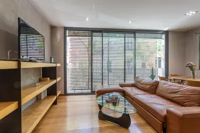 a living room with a brown leather couch and a table at My Space Emirates - Bright Apartment in Gracia with shared Pool in Barcelona