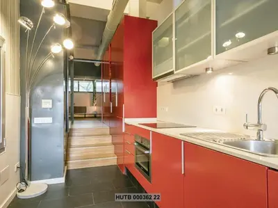 a kitchen with red cabinets and a sink and a hallway at Alcam Futbol Pequeño in Barcelona