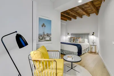 a bedroom with a bed and a chair and a table at CATERINA Correos in Barcelona