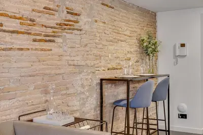 a brick wall with two chairs and a table at CATERINA Correos in Barcelona