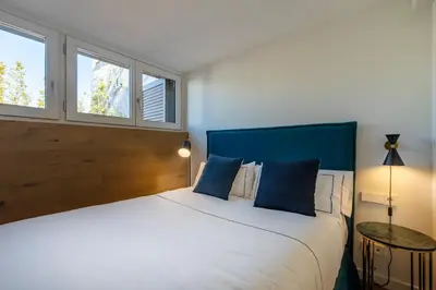 a bedroom with a large bed and two windows at CATERINA Correos in Barcelona