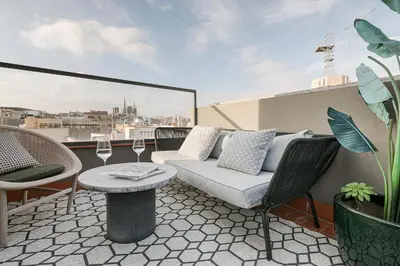 a balcony with a couch and a table and chairs at CATERINA Correos in Barcelona