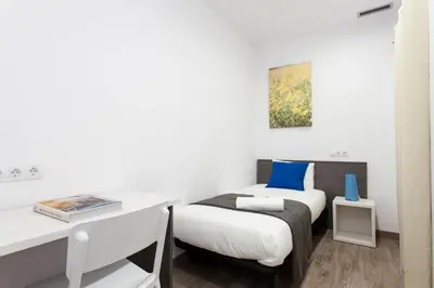 a bedroom with a bed and a desk and a table at 2512 - AB Comte dUrgell P-II in Barcelona