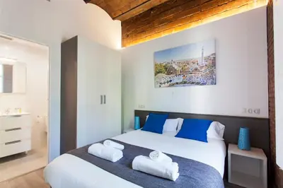 a bedroom with a large bed with blue pillows at 2512 - AB Comte dUrgell P-II in Barcelona