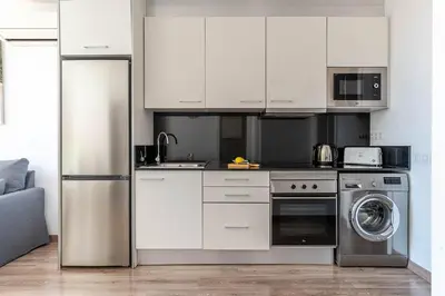 a kitchen with white cabinets and a washer at 2514 - AB Comte dUrgell V-II in Barcelona