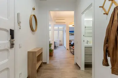 a hallway with white walls and wood floors and a mirror at 4190 - AB Comte dUrgell P-I in Barcelona