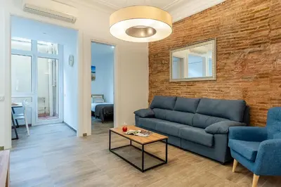 a living room with a couch and a brick wall at 4190 - AB Comte dUrgell P-I in Barcelona