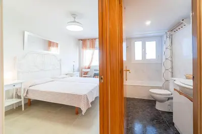 a bedroom with a bed and a tub and a toilet at Horizonte Azul Sitges in Sitges