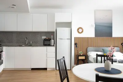 a kitchen and dining room with a table and a kitchen and a living room at StayCampNou Studio with Balcony in Hospitalet de Llobregat