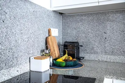 a kitchen counter with a bowl of fruit and a cutting board at StayCampNou Studio with Balcony in Hospitalet de Llobregat