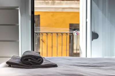 a towel sitting on top of a bed next to a window at Apartamento La Boqueria 3 in Barcelona