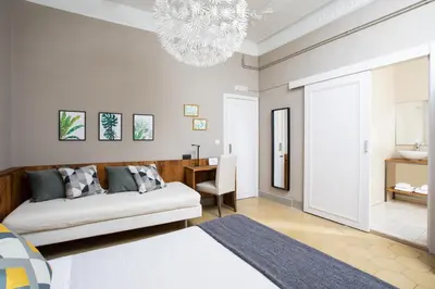 a living room with a bed and a chandelier at Jardinets Guest House in Barcelona