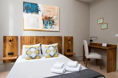 a bedroom with a bed with a desk and a chair at Jardinets Guest House in Barcelona