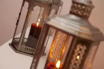 a candle in a lantern with a candle holder at Jardinets Guest House in Barcelona