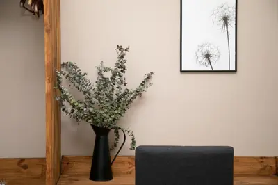 a black vase filled with flowers on a table at Jardinets Guest House in Barcelona