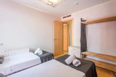 a bedroom with two beds and a door with a window at My Space Emirates - Fully equipped apartments near the Beach with shared pool in Barcelona