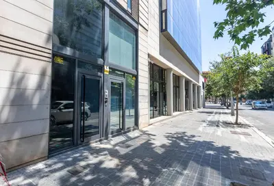 a building with glass doors on the side of a street at My Space Emirates - Fully equipped apartments near the Beach with shared pool in Barcelona