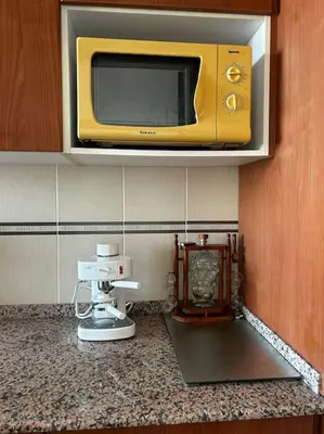 a microwave on a cabinet above a kitchen counter at Apartamento a primera línea de Mar in Pineda de Mar