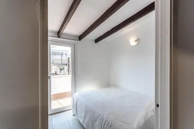 a bedroom with a white bed and a window at Apartamento La boqueria Atic in Barcelona