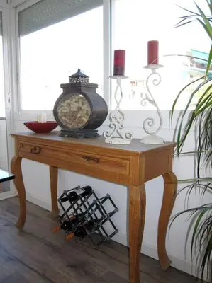 a wooden table with a clock on top of it at Preciosa casa en el centro con terraza y patio in Sitges