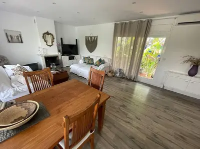 a living room with a table and a living room with a bed at Preciosa casa en el centro con terraza y patio in Sitges